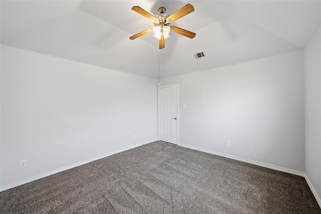 Vaulted ceiling featuring a central wood-finish ceiling fan with integrated lighting and neutral carpeting