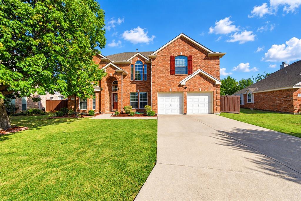 Two-story brick exterior featuring a multi-gabled roofline, an arched entryway, decorative window shutters, and an attached two-car garage Two-story brick exterior featuring a multi-gabled roofline, an arched entryway, decorative window shutters, and an attached two-car garage