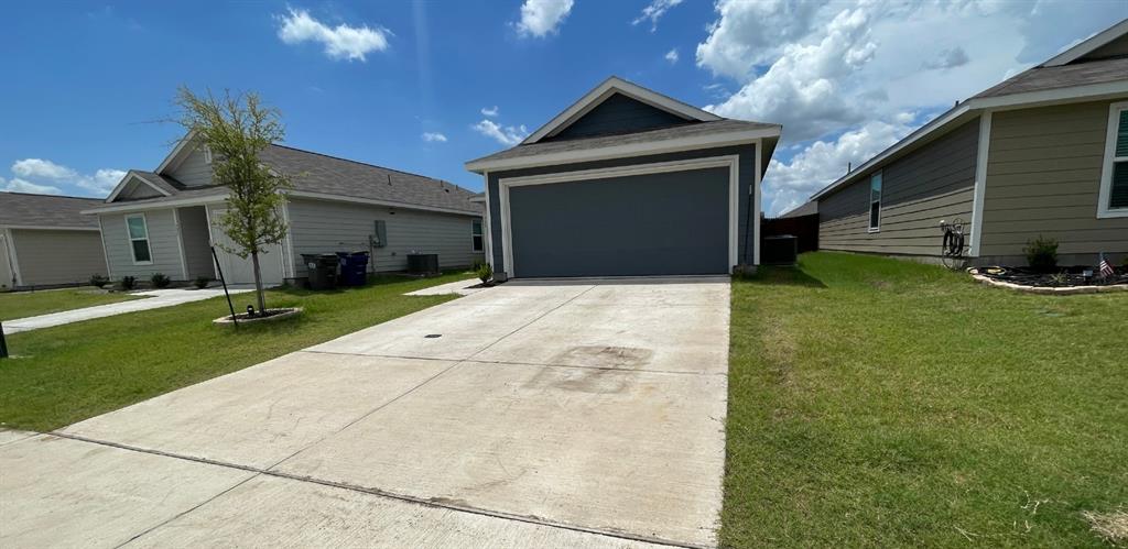 Single-story exterior featuring lap siding, a pitched roofline, a two-car garage, and a concrete driveway