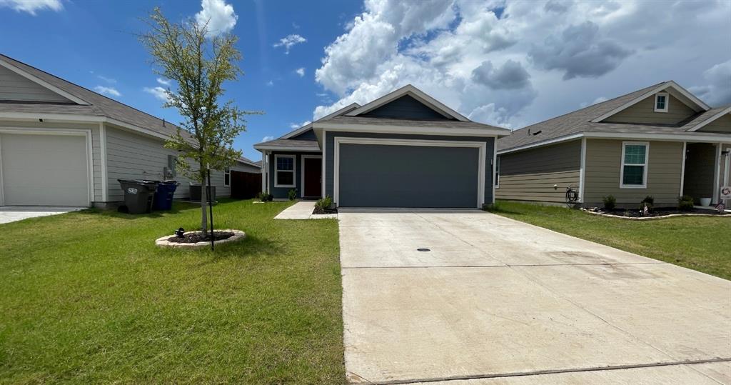 Single-story residence featuring a gray lap-siding exterior, dual-pitched roofline, front-facing two-car garage, and concrete driveway