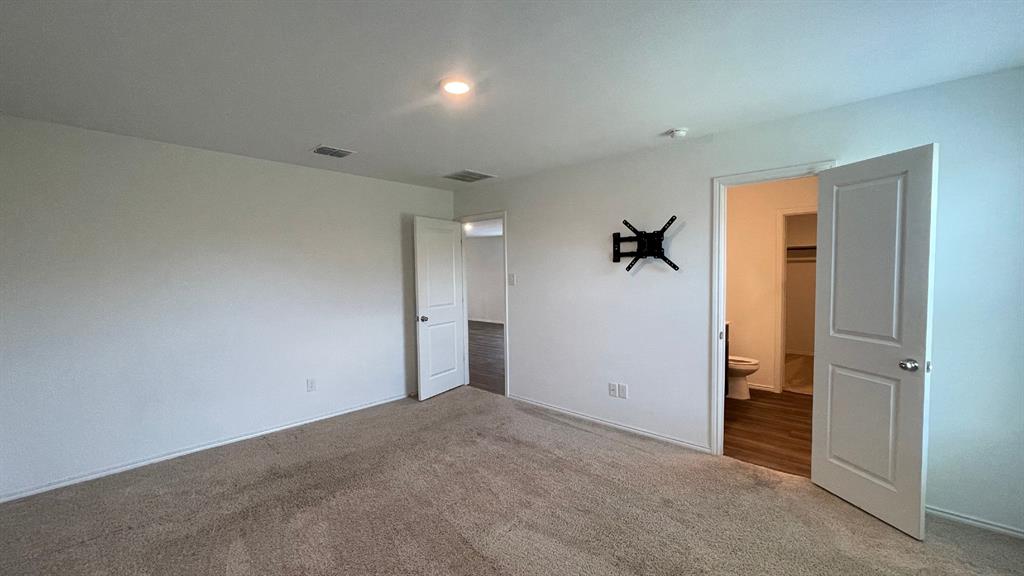 Neutral interior space featuring carpeted flooring, two-panel interior doors, and recessed lighting