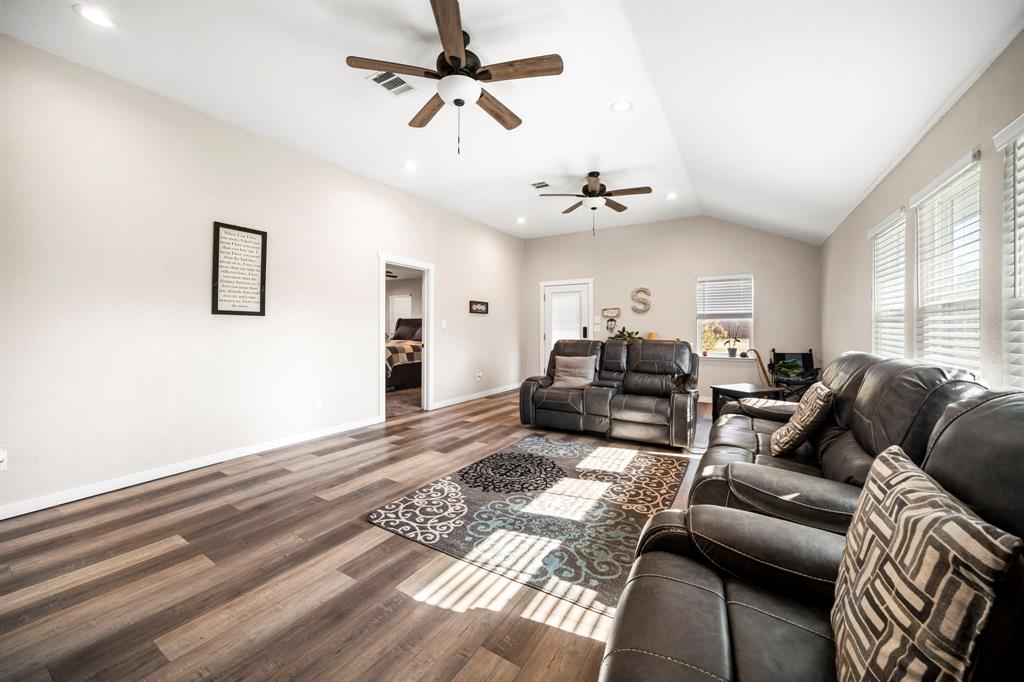 Vaulted ceilings, wood-finish flooring, recessed lighting, and dual ceiling fans