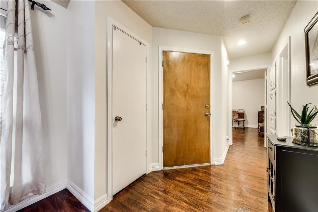 Entryway featuring wood-finish flooring, a solid wood entry door, a recessed ceiling light, and white interior doors
