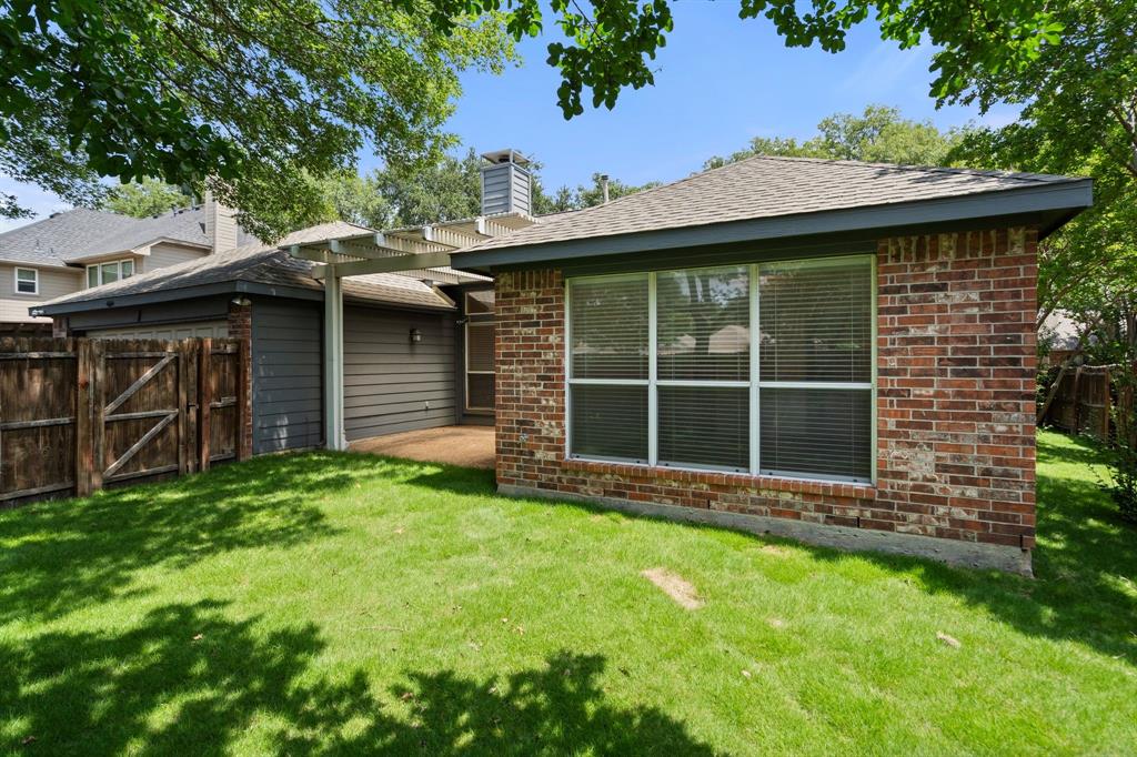 Rear view of property featuring brick siding, a chimney, and a patio area