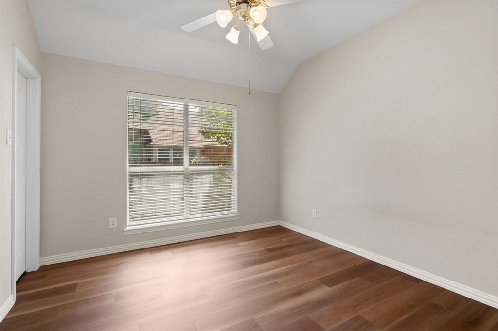 Spare room featuring lofted ceiling, ceiling fan, and wood finished floors