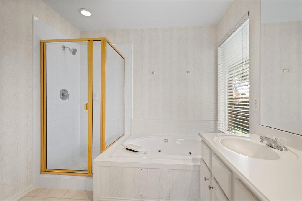 Full bathroom with a stall shower, vanity, a whirlpool tub, wallpapered walls, and tile patterned flooring