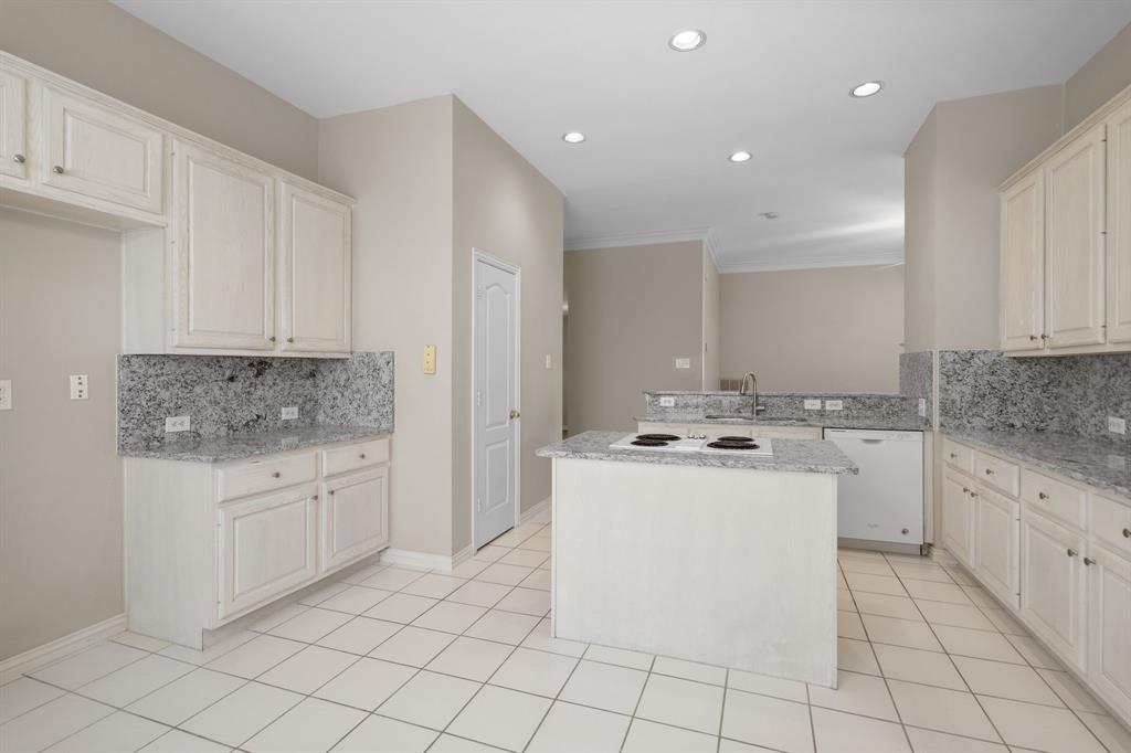 Kitchen with white appliances, decorative backsplash, recessed lighting, a peninsula, and light stone counters