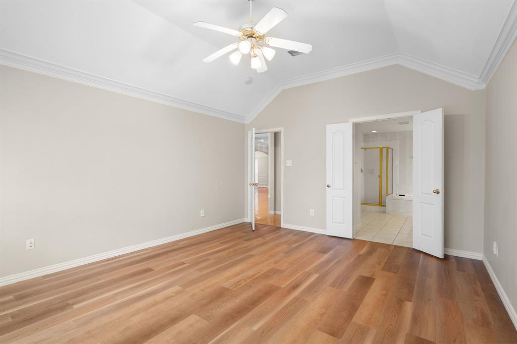 Unfurnished bedroom featuring vaulted ceiling, light wood-type flooring, ceiling fan, and connected bathroom