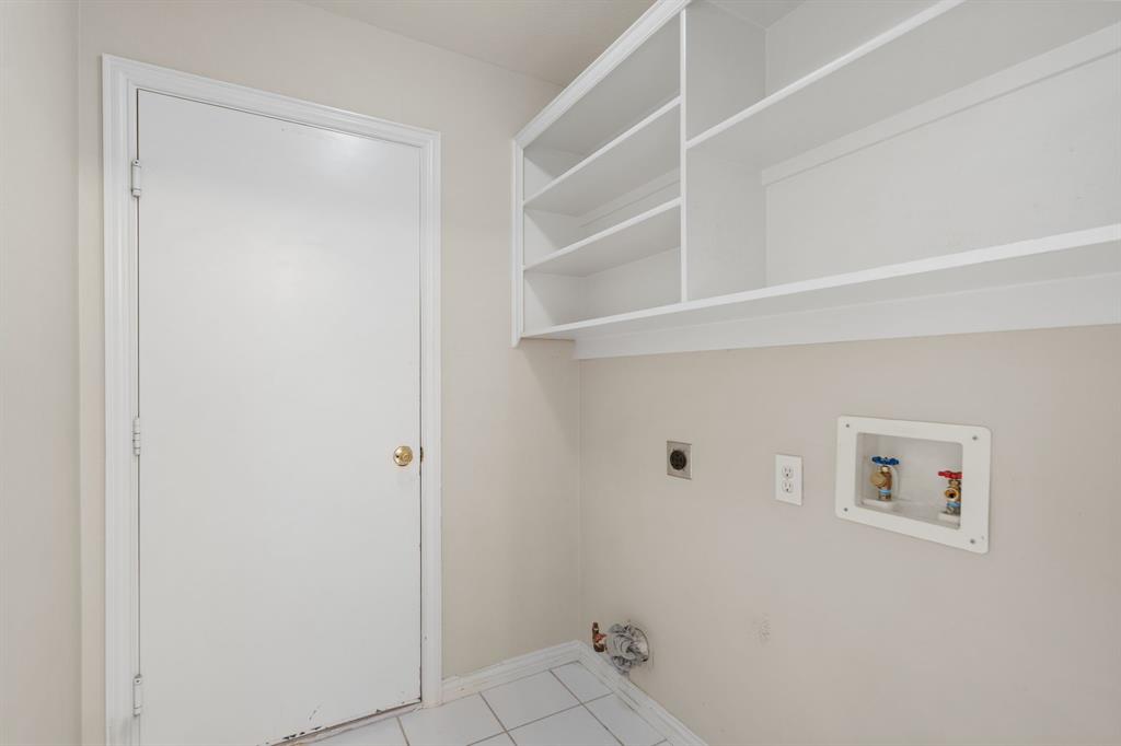 Washroom with hookup for an electric dryer, hookup for a washing machine, light tile patterned floors, and gas dryer hookup