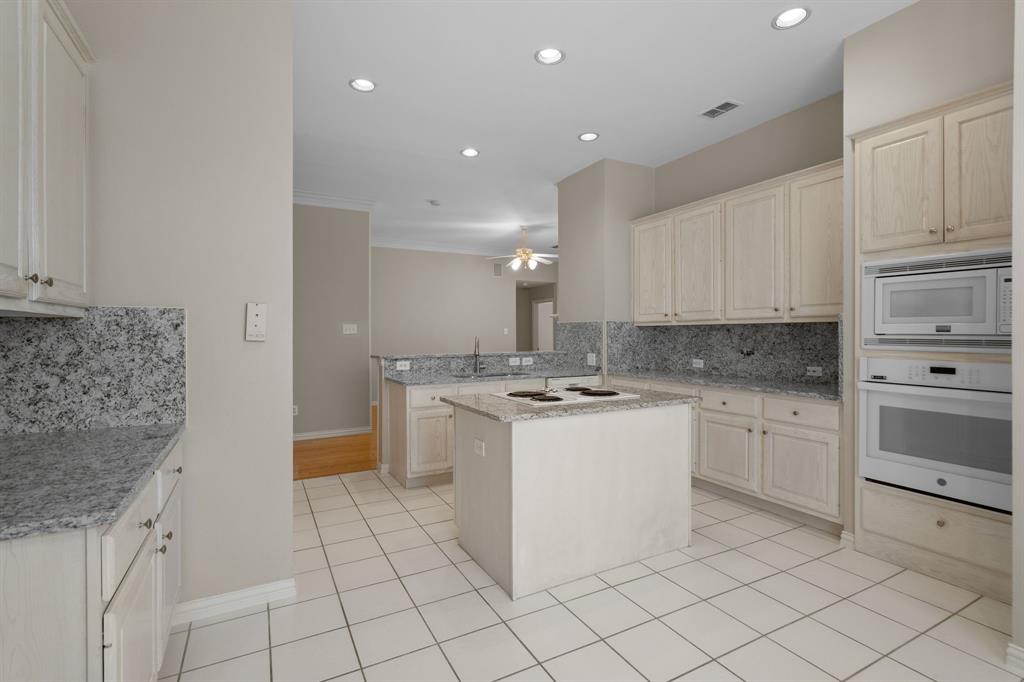 Kitchen with white appliances, a ceiling fan, tasteful backsplash, recessed lighting, and a peninsula