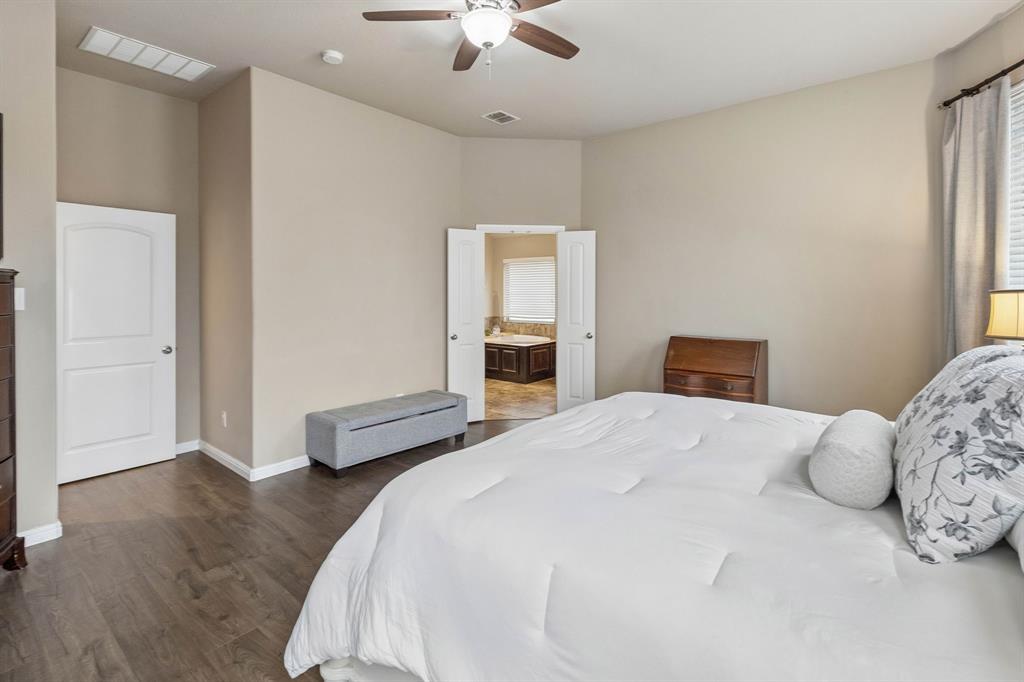 Another view of the primary bedroom highlights the elegant French doors leading into the private ensuite bathroom.