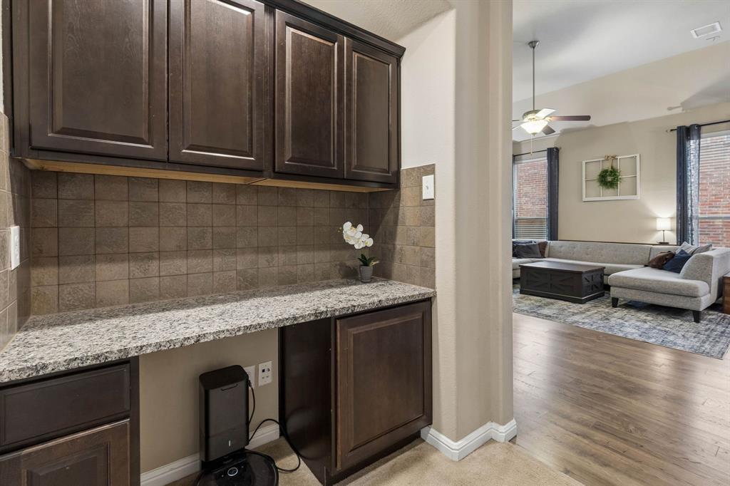 Built in desk area with granite countertops and stained wood cabinets.