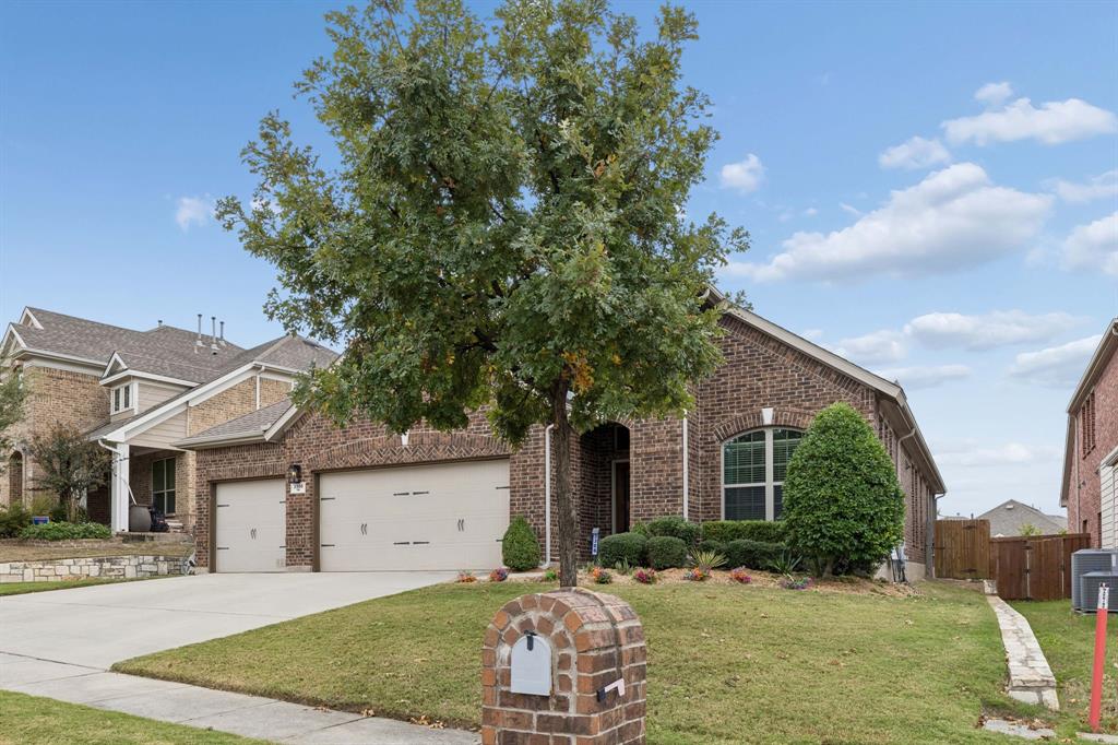 This home makes a beautiful first impression with its timeless brick exterior, lush landscaping, mature foliage, and spacious driveway with room for three vehicles.