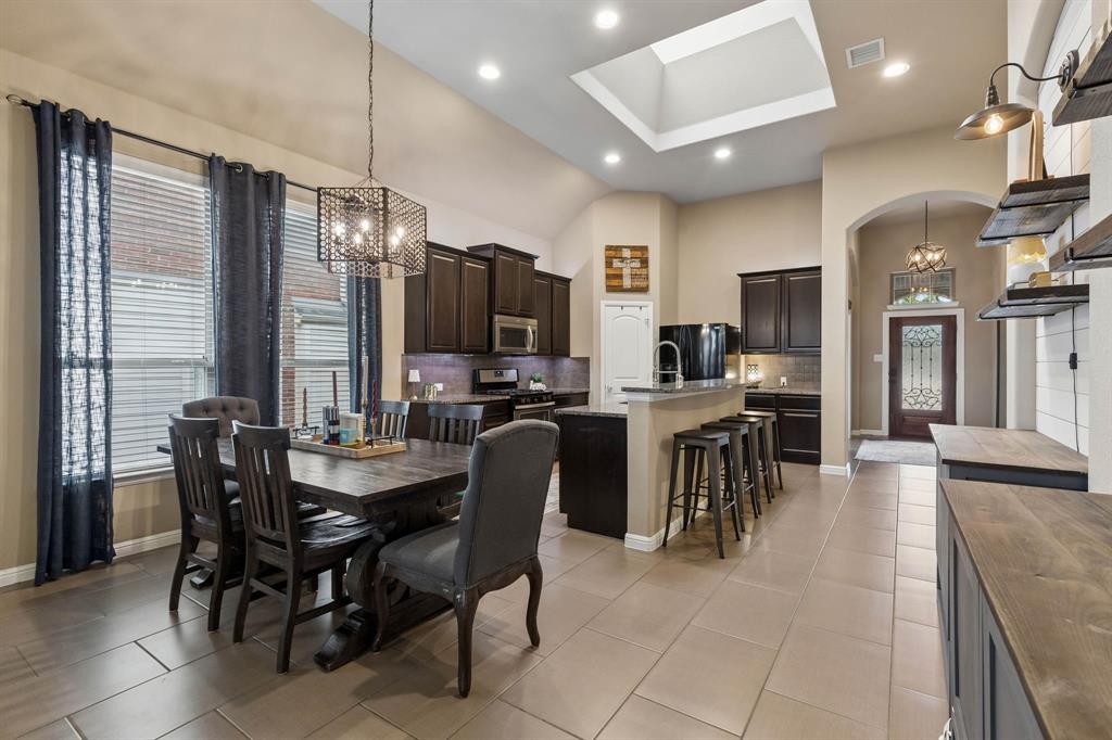 This view highlights the kitchen and dining area's large skylight, abundant natural light, and seamless flow throughout the home.