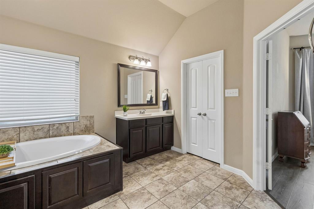 This view showcases the second vanity, additional storage, and convenient access to the spacious walk-in closet.