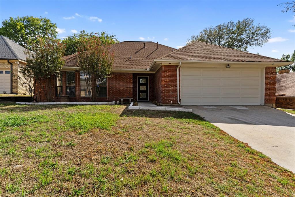 Single-story brick exterior featuring a multi-gabled roofline, an attached two-car garage, and a covered entryway with a multi-pane glass door