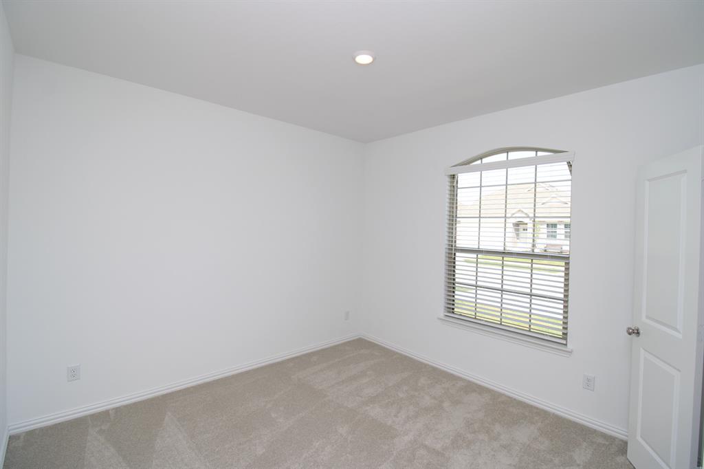 Neutral-toned wall finish, wall-to-wall carpeting, arched window featuring horizontal blinds, and recessed lighting