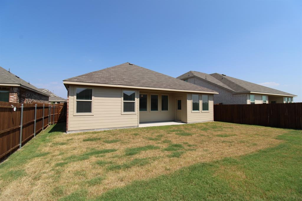 Rear exterior featuring horizontal lap siding, a hipped roof with asphalt shingles, a covered concrete patio, and a fenced backyard