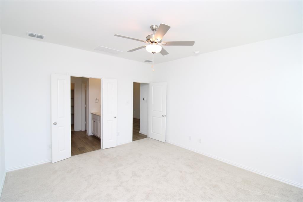 Neutral interior featuring wall-to-wall carpeting, brushed-nickel ceiling fan with integrated lighting, and multiple paneled doors