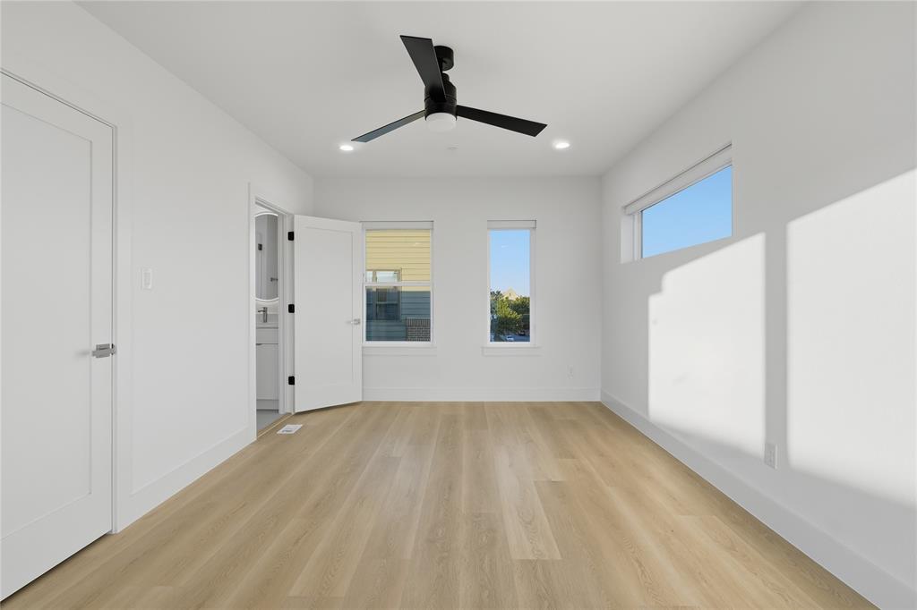 Room featuring wood-finish flooring, recessed lighting, a modern ceiling fan, multiple windows, and a horizontal clerestory window