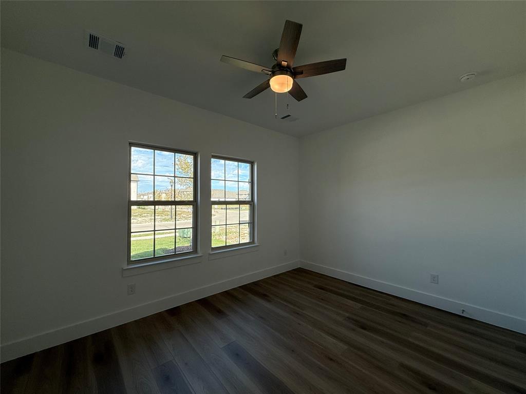 Wood-finish flooring, dual grid-pane windows, and central ceiling fan with integrated lighting