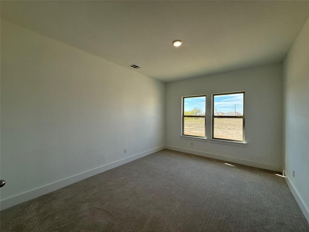 Neutral-toned carpeting, smooth-finish walls, and dual double-pane windows providing natural light