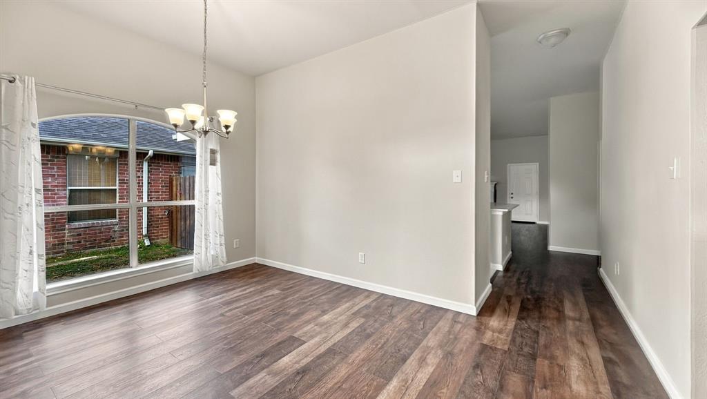 Vaulted ceilings, wood-finish flooring, stone-surround fireplace, tile flooring, and a kitchen island with stone-finish countertops