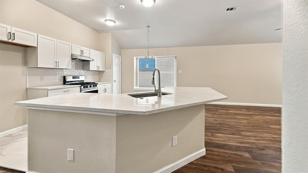 Utility area featuring white walls, a six-panel door, built-in shelving, stone-patterned tile flooring, and dedicated washer and dryer hookups