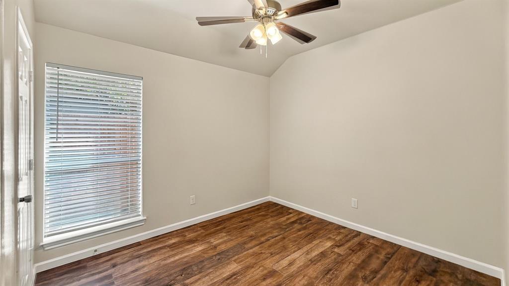 Wood-finish flooring, neutral wall tones, multi-light ceiling fan, and window fitted with horizontal blinds