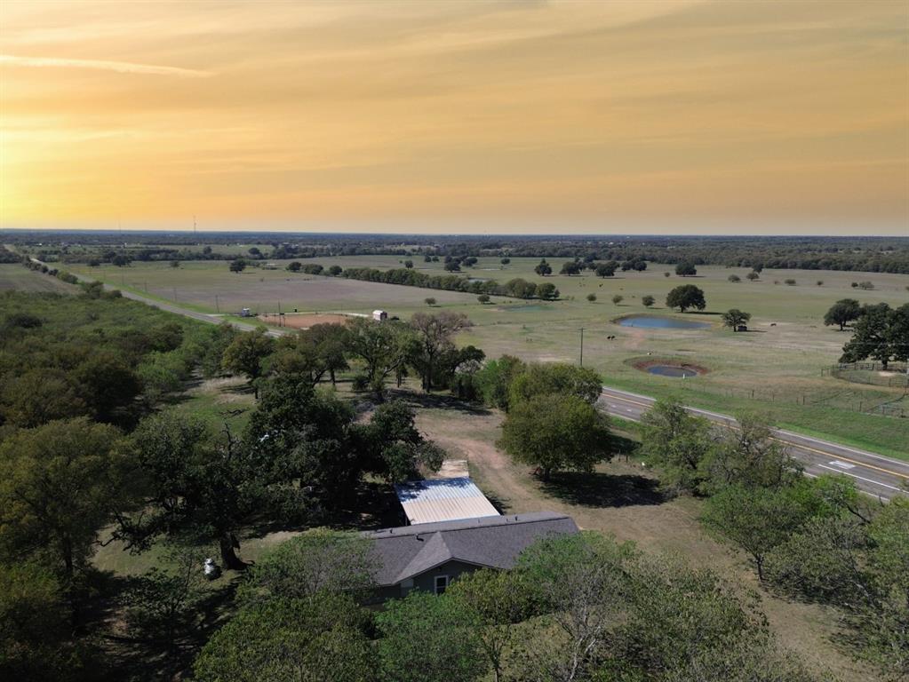 Aerial perspective featuring expansive acreage, mature shade trees, and two bodies of water