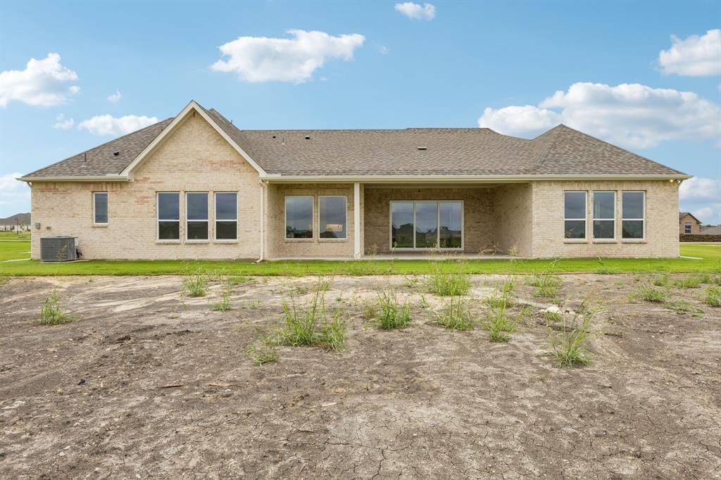 Single-story brick exterior featuring a multi-gabled roofline, covered rear patio, and expansive grid-pane windows