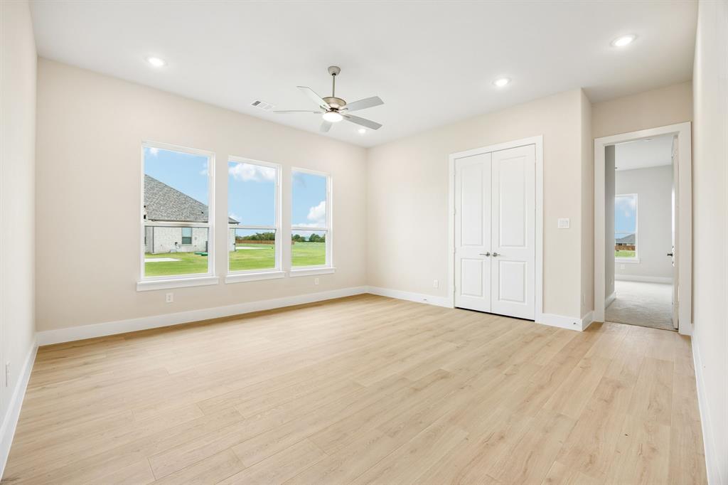 Neutral interior space featuring wood-finish flooring, recessed lighting, a ceiling fan, and double-panel doors