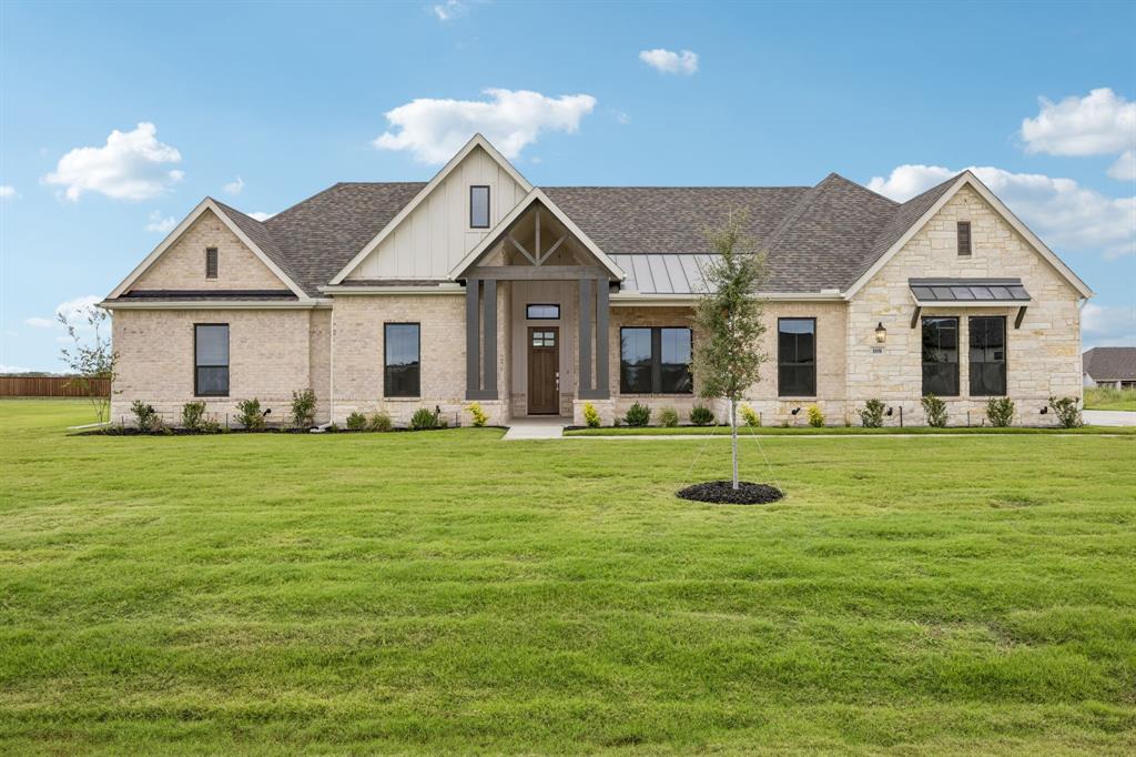 Single-story residence featuring a mixed-material facade of stone and board-and-batten siding, a prominent covered entryway, metal roofing accents, and multi-gabled architectural design