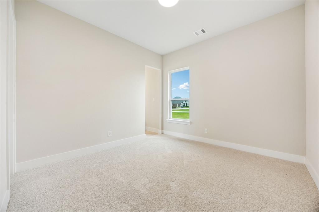 Neutral-toned room featuring neutral carpeting, crisp white walls, and a single-pane window