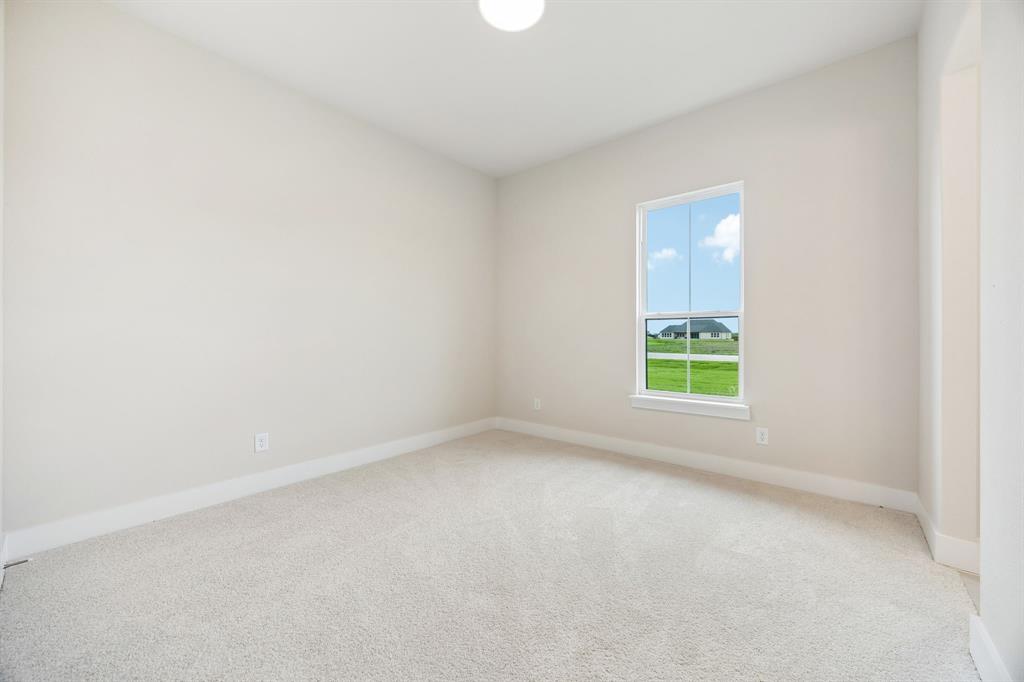 Neutral-toned interior room featuring wall-to-wall carpeting, a single-hung window, and a flush-mount ceiling light
