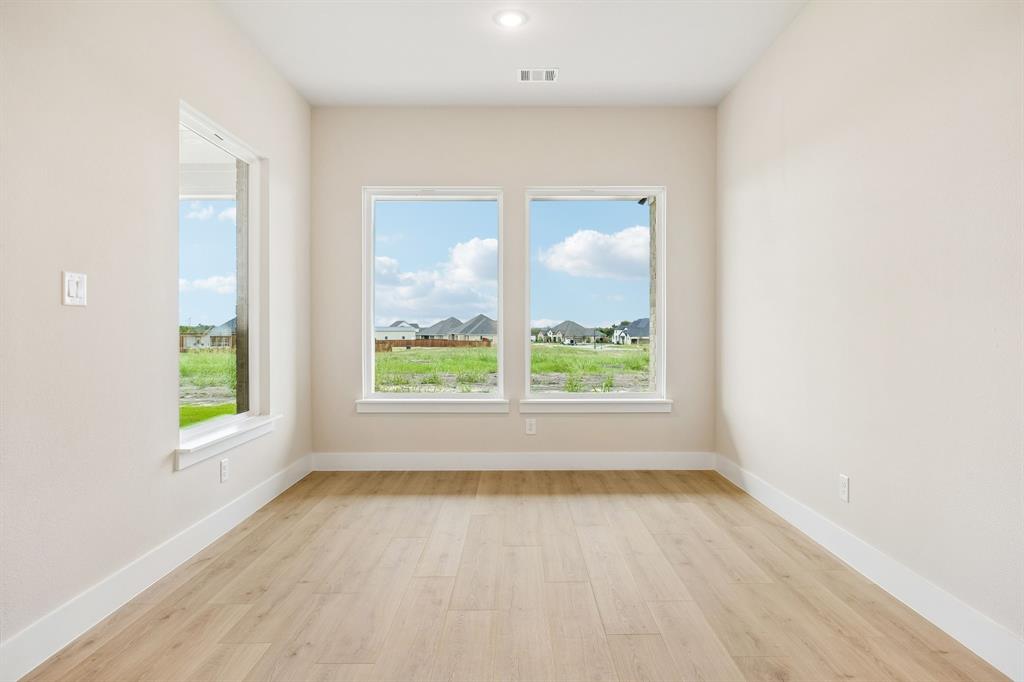 Room featuring wood-finish flooring, recessed lighting, and multiple windows providing natural light