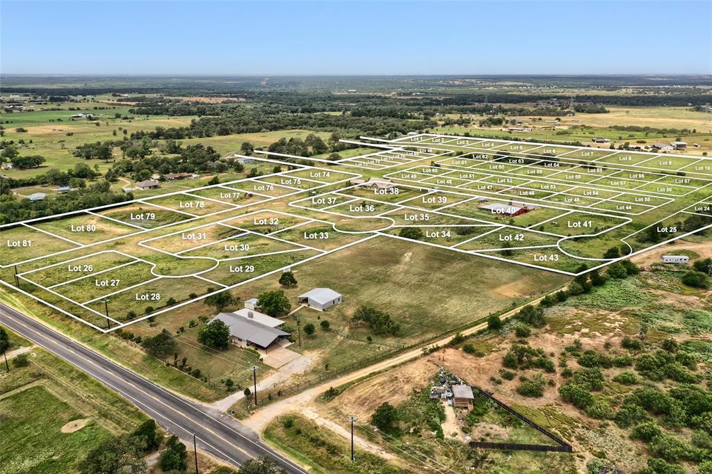 Aerial perspective of expansive acreage featuring partitioned residential lots, established infrastructure, and proximity to paved public roadways Aerial perspective of expansive acreage featuring partitioned residential lots, established infrastructure, and proximity to paved public roadways