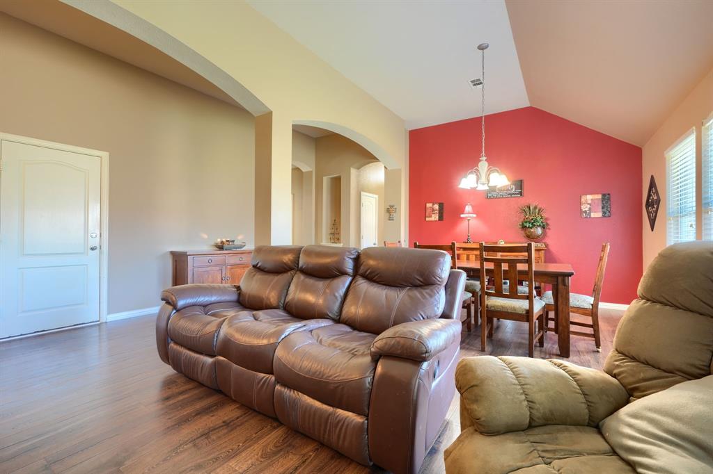 Vaulted ceilings, wood-finish flooring, architectural arched openings, and a prominent accent wall Vaulted ceilings, wood-finish flooring, architectural arched openings, and a prominent accent wall