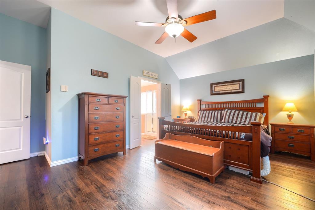 Vaulted ceilings, wood-finish flooring, and a central ceiling fan with integrated light fixture