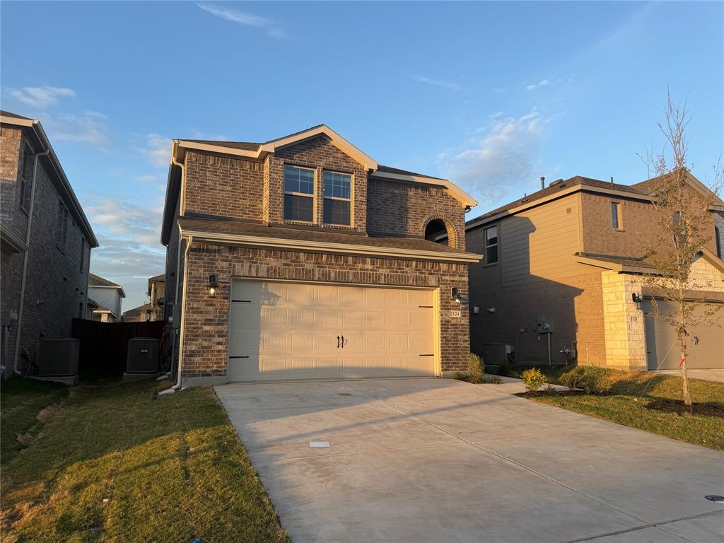 Two-story brick exterior featuring a multi-gabled roofline, concrete driveway, and attached two-car garage
