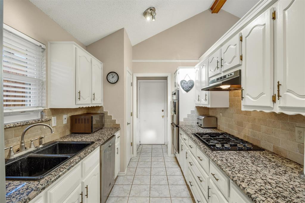Kitchen featuring white cabinetry, granite countertops, stone-tile backsplash, stainless steel built-in oven, and a gas cooktop
