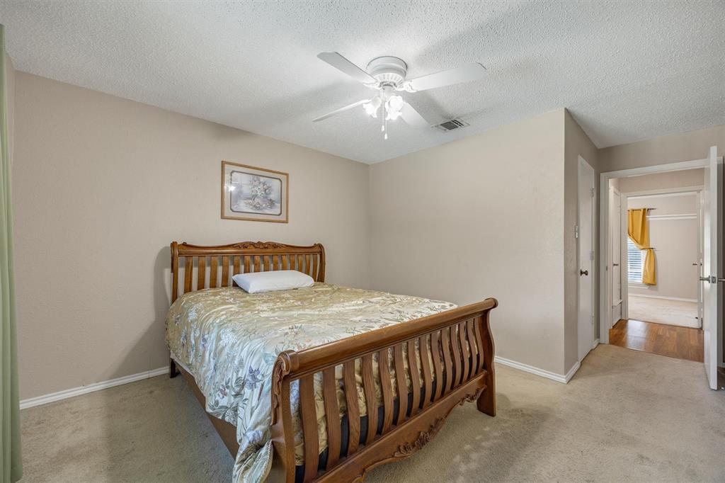 Room featuring neutral wall tones, carpeted flooring, and a ceiling-mounted light fixture with an integrated fan