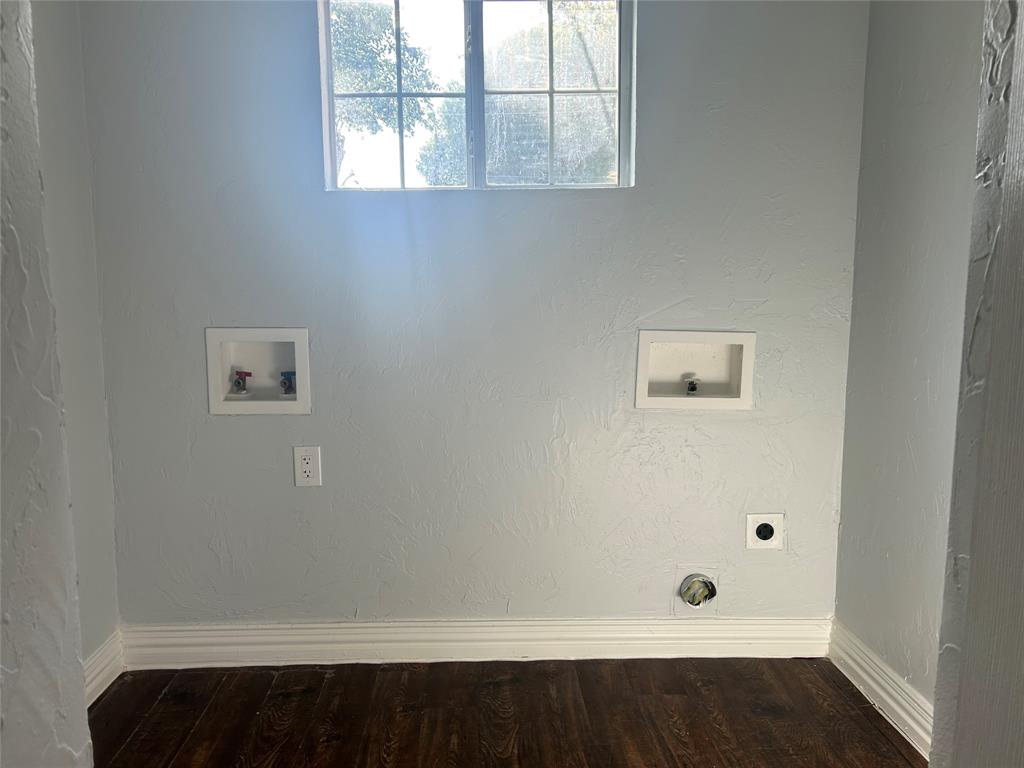 Utility area featuring wood-finish flooring, textured wall finishes, a multi-pane window, and integrated hookups for laundry appliances Utility area featuring wood-finish flooring, textured wall finishes, a multi-pane window, and integrated hookups for laundry appliances