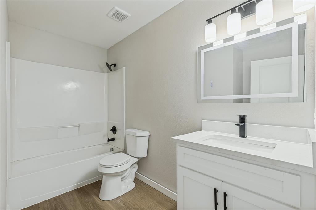 En suite primary bathroom with new vanity, mirror, and lights