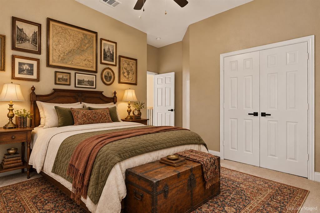 Vaulted ceiling with a central paddle fan, neutral wall paint, and white double-panel closet doors featuring matte black hardware