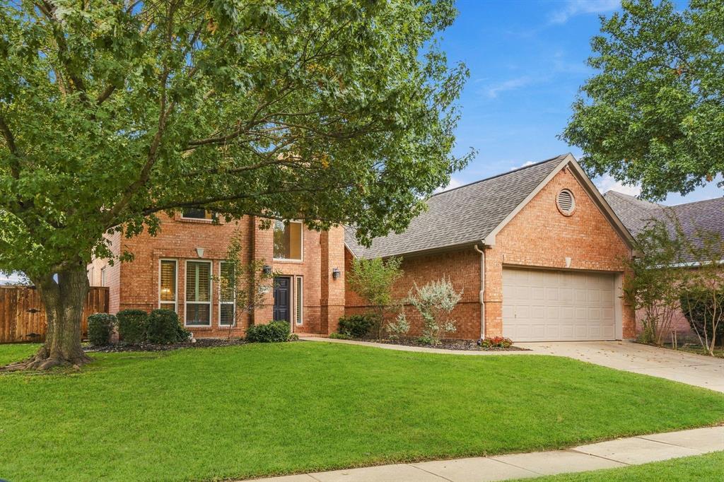 Brick exterior featuring a multi-gabled roofline, an integrated two-car garage, large vertical windows, and a circular accent window