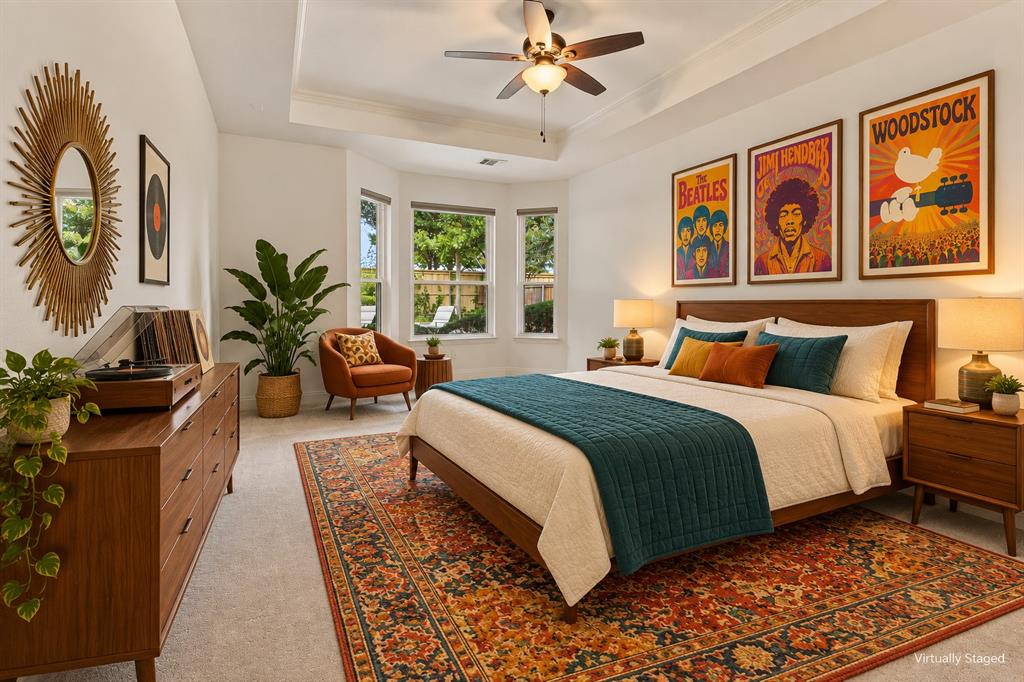 Tray ceiling with a central multi-blade ceiling fan and three-pane bay window