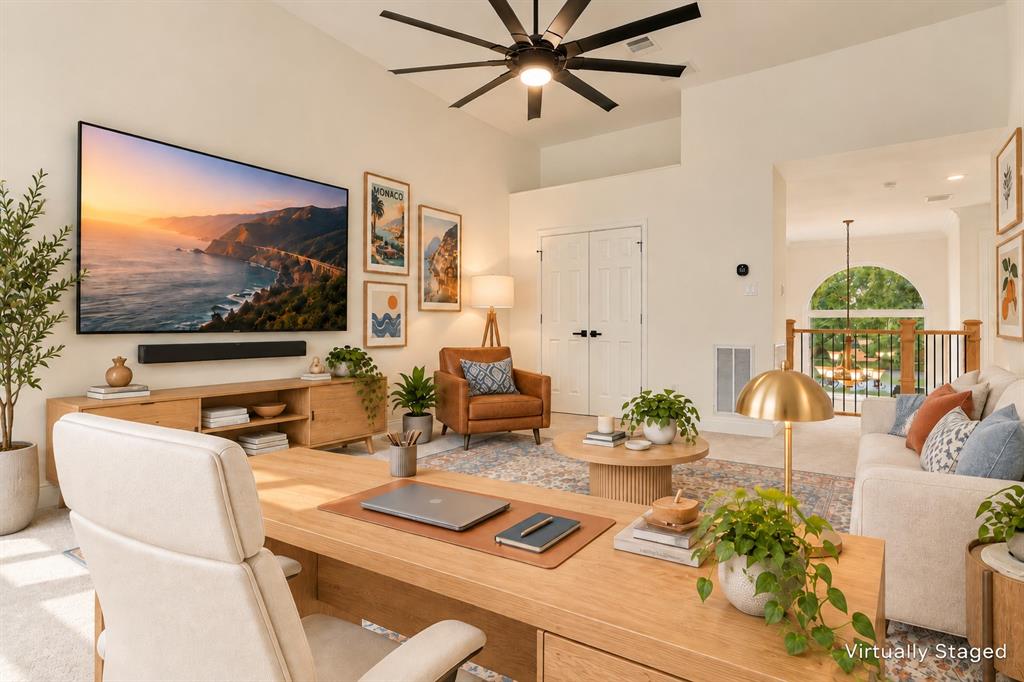 High ceilings featuring a large-format multi-blade ceiling fan, recessed lighting, and a distinct arched window element