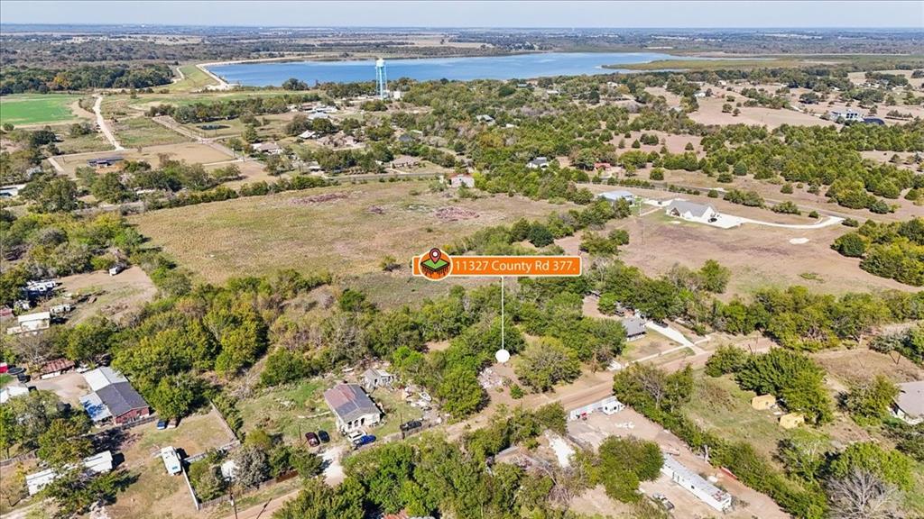 Aerial perspective of expansive acreage featuring mature trees, open grassy areas, and proximity to a large body of water Aerial perspective of expansive acreage featuring mature trees, open grassy areas, and proximity to a large body of water