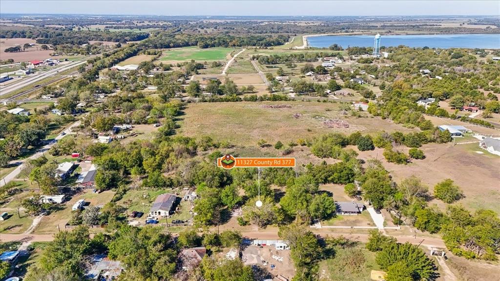 Aerial perspective of expansive acreage featuring mature trees, open pasture, and proximity to water